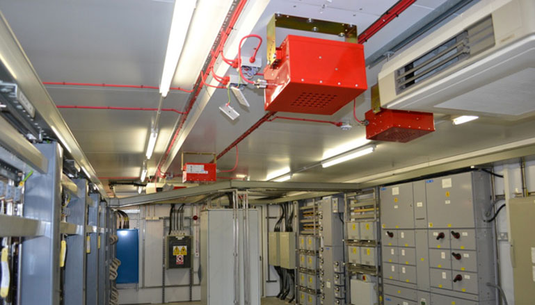 Sistema de combate a incêndio com tubulações e válvulas vermelhas instaladas no teto de um edifício, projetado para controle e prevenção de incêndios em ambientes internos.