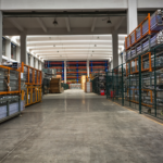 Galpão industrial organizado com estruturas metálicas e materiais armazenados, ilustrando a importância da prevenção de incêndio industrial em ambientes de grande porte.
