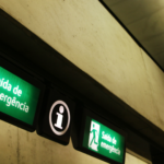 Sinalização de segurança fotoluminescente indicando saída de emergência, garantindo orientação e visibilidade em ambientes com baixa iluminação ou falta de energia.