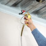 Aplicação de revestimento resistente ao fogo em estrutura metálica, solução utilizada na proteção passiva para aumentar a resistência da edificação em caso de incêndio.